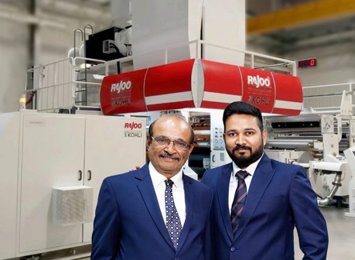 Chandrakant Bhalara managing director of Balaji and Pranav Bhalara director of Balaji in front of the new Rajoo-Kohli extrusion, coater, lamination line. Photo Rajoo